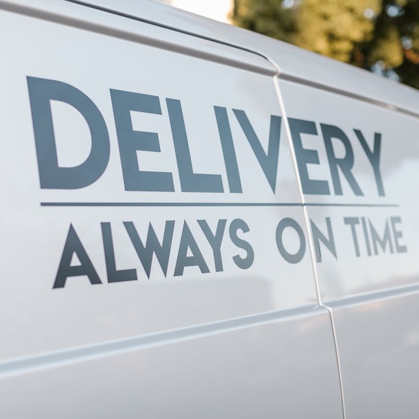 Weißes Lieferfahrzeug mit der Aufschrift "Delivery Always on Time".
